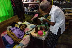 Devotion: Doel prepares drink, food and medicine for his sick wife, Yustina Sumarni, 80. JP/Anggertimur Lanang Tinarbuko