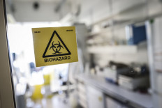 A picture taken in a laboratory of the National Reference Center (CNR) for respiratory viruses at the Institut Pasteur in Paris on January 28, 2020 shows a biohazard sticker on the entrance of a room. 