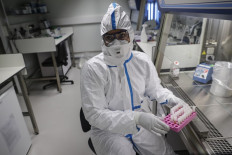 A laboratory operator wearing a protective gear handles patients' samples in a laboratory of the National Reference Center (CNR) for respiratory viruses at the Institut Pasteur in Paris on January 28, 2020. - The CNR analyses the tests for respiratory viruses among which coronavirus. The deadly new coronavirus that has broken out in China, 2019-nCoV, has so far killed 106 people and infected over 4,000 -- the bulk of them in and around Wuhan. 