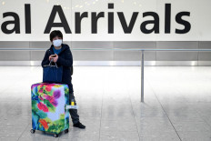Passengers wear face masks as the push their luggage after arriving from a flight at Terminal 5 of London Heathrow Airport in west London on Jan. 28, 2020.The airline industry is never going to get back to the way it was before coronavirus, warned the former chief executive of British Airways-owner IAG , adding it will be smaller but more efficient in the future.