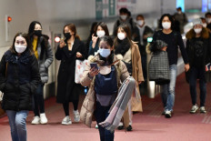 Passengers from overseas arrive at Tokyo's Haneda International Airport passenger terminal on January 28, 2020. - Japan sent a first plane to the Chinese city of Wuhan on Janusary 28 night to evacuate citizens from the epicentre of a deadly virus outbreak, a foreign ministry official said. 