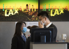 Airline check in staff wear face masks to protect against the spread of the Coronavirus at the Los Angeles International Airport, California, on January 29, 2020. 