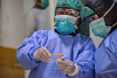 Hospital workers wear protective gear as they check blood tests taken from Indonesian students who returned from China in quarantine at a hospital in Banda Aceh on Jan. 29. 