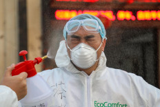 This photo taken on February 3, 2020 shows a doctor being disinfected by his colleague at a quarantine zone in Wuhan, the epicentre of the new coronavirus outbreak, in China's central Hubei province. - The number of total infections in China's coronavirus outbreak has passed 20,400 nationwide with 3,235 new cases confirmed, the National Health Commission said on February 4. 