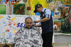 Acting president director of PT Transportasi Jakarta (Transjakarta), Yoga Adiwinarto, has his hair shaved as a token of gratitude after the public transportation service reaching 1 million daily customers.