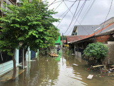 Residents wade through the water in the flood-stricken Total Persada housing complex in Tangerang, Banten on Feb. 6.