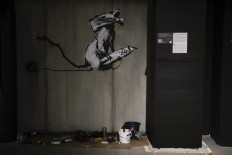 This picture taken on October 15, 2019 shows a replica of British street artist Banksy's artwork entitled 'Fifty years since the uprising in Paris 1968. The birthplace of modern stencil art', which original was painted in Paris in 2018 and stolen in September 2019, displayed as part of the exhibition 'The world of Banksy, the immersive experience' at the Espace Lafayette-Drouot in Paris. 