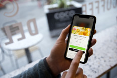 A user of the Karma food-sharing app browses foods available from the Coco Di Mama food outlet chain of stores--a partner of Karma--in this posed photograph taken in London on January 22, 2020. 
