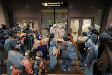Officials (C) check details of Vietnamese citizens repatriated from Wuhan, where the SARS-like novel coronavirus originated, upon their arrival at the Van Don airport in Vietnam's Quang Ninh province on February 10, 2020.
