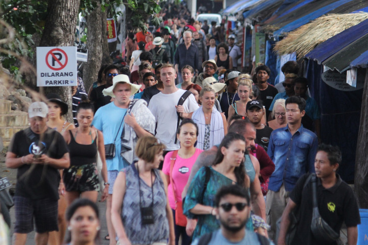 Tourists walk to the pick-up point in Sanur beach, Denpasar after their return fromNusa Penida Island in Bali on Monday. The Bali Tourism Agency has said a reportpublished on Feb. 8 by the UK-based Daily Mailthat said Bali had turned into a ghost town following a ban on tourists from China amid coronavirus fear was not true.