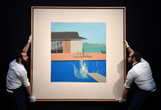 Gallery assistants pose next to an artwork entitled 'The Splash' 1966, by British artist David Hockney, expected to realize £20-£30 million (23.6 - 35.4 million Euro, 25.9 - 38.8 million dollars) at a Contemporary Art Evening Auction on February 11, during a photo call at Sotheby's Galleries in central London on February 7, 2020.
