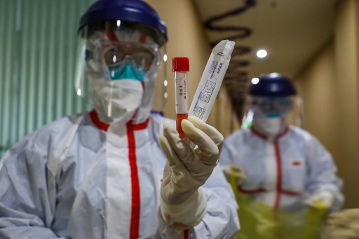 This photo taken on Feb. 4 shows a medical staff member showing a test tube after taking samples taken from a person to be tested for the new coronavirus at a quarantine zone in Wuhan, the epicenter of the outbreak, in China's central Hubei province. 
