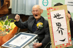In this Japan Pool picture received via Jiji Press on February 12, 2020, 112-year-old Japanese man Chitetsu Watanabe poses next to calligraphy reading in Japanese 'World Number One' after he was awarded as the world's oldest living male in Joetsu, Niigata prefecture. 