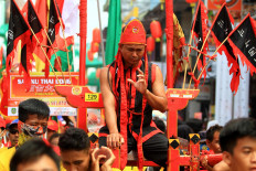 A tatung shows off his ability of sitting on a machete during the parade. JP/HS Putra