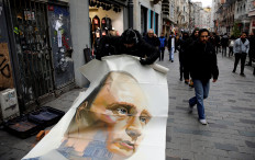 Russian artist and former mayor of Arkhangelsk Alexander Donskoy picks up a portrait of Russian President Vladimir Putin at Istiklal Street in Istanbul, Turkey February 15, 2020. 