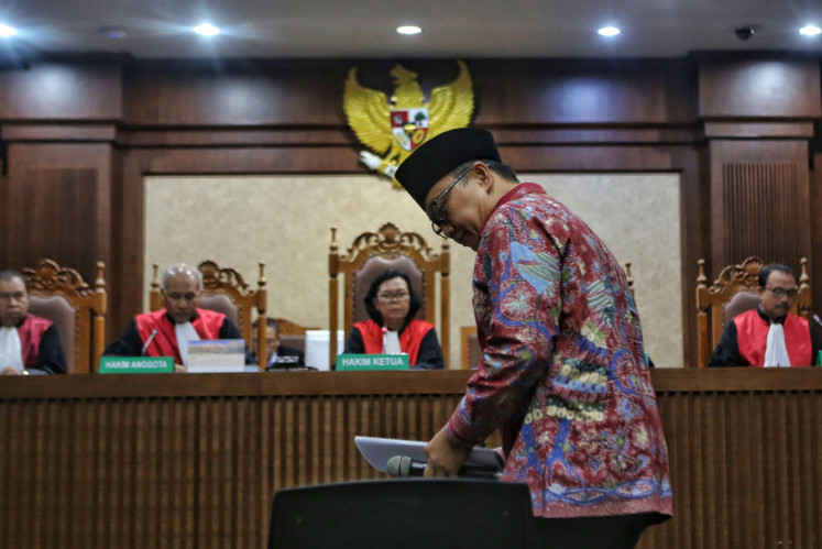 Former Youth and Sports Minister Imam Nahrawi walks to his seat before Corruption Eradication Commission (KPK) prosecutors read out his indictment during a hearing at the Jakarta Corruption Court on Feb. 14, 2020.