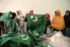 Final check: Women prepare green flags that have the star and crescent symbol. They later hoisted the flags to mark the beginning of Serak Gulo. JP/Ramadhani