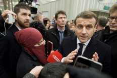 Macron draws fire as admirer flouts law over Islamic face veil