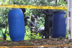 National Armed Forces Rapid Disaster Relief Response Command personnel from the Chemical, Biological, Radioactive, Nuclear Unit (KBRN) take samples of soil exposed to Cesium 137, a radioactive substance, in the Batan Indah housing complex in Serpong, South Tangerang, Banten, on Feb. 16. 