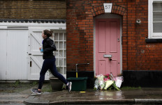 Flowers lie outside British television presenter Caroline Flack's old house in Islington, London, on February 16, 2020. 