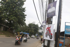 Vehicles pass by posters promoting mayoral hopefuls on Jl. Puspitek Raya in South Tangerang, Banten, on Wednesday, Feb. 19. 