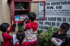 Children browse through books from a book-sharing box in Jatipulo subdistrict, West Jakarta. The books have all been donated to the community in its initiative to turn the neighborhood into a literacy kampung. JP/Afriadi Hikmal