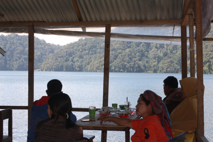 Serenity: Locals and tourists enjoy food and drinks at a stall with a view on Lake Lau Kawar.