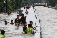 Children play in floodwater in the Pondok Maharta housing complex, Pondok Kacang, South Tangerang, Banten, on Tuesday (02/25/2020). 