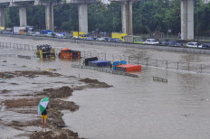 Floodwater engulfs trucks on the Jakarta-Cikampek toll road in Bekasi, West Java, on Tuesday.