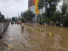 Residents wade through floodwater on Jl. Gunung Sahari Saya in North Jakarta on Tuesday, Feb. 25.