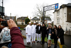 People pose for a picture under the unveiled sign to rename a street in Feltham 'Freddie Mercury Close', in Greater London, Britain February 24, 2020. 