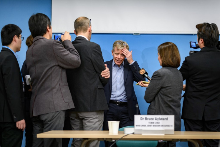Team leader of the joint mission between World Health Organization (WHO) and China on COVID-19 Bruce Aylward (C) talks to journalists following a press conference at the WHO headquarters on February 25, 2020 in Geneva. - The world is 