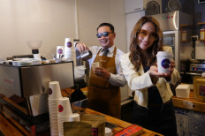 West Java Governor Ridwan Kamil (left) and actress-cum-singer Cinta Laura pose for a photograph at the newly opened Jabarano café in Melbourne, Australia, during its launch on Feb. 24.