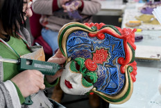 An artist works on a carnival mask at the Venice Art Mask workshop in Shkoder, Albania, on February 20, 2020. 
