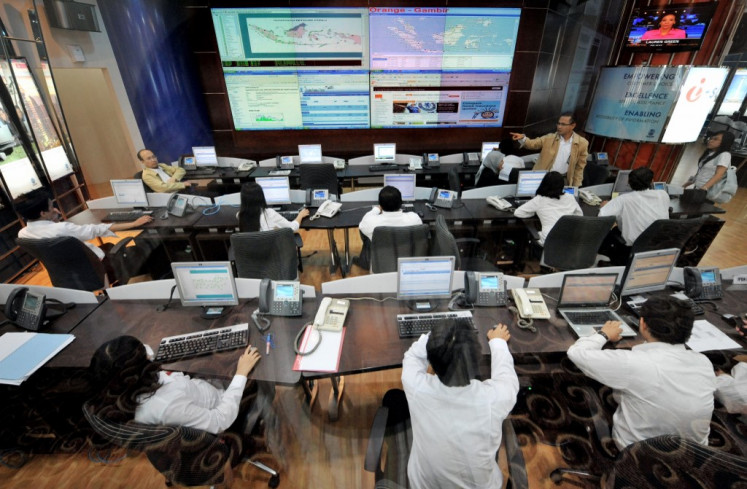 Information technology experts of TELKOM, Indonesia's leading telecommunication company, work at the central monitoring section of their headquarters in Jakarta on April 15, 2009. 