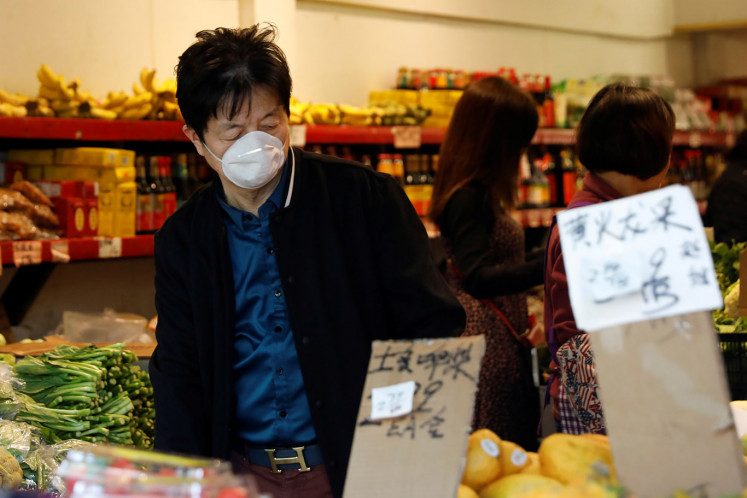 A man wears a face mask shopping at a market in the Chinatown section of San Francisco, California, U.S., February 25, 2020.   