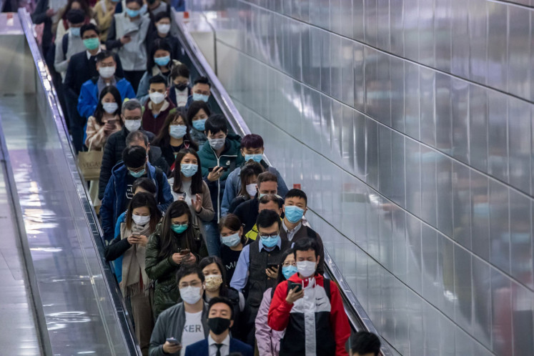 People wearing protective masks walk at Hong Kong Station of MTR in Hong Kong, China, on Tuesday, Feb.11, 2020.  