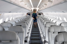 A cabin crew inspects inside an Embraer SA 195-E2 aircraft at the Singapore Airshow held at the Changi Exhibition Centre in Singapore, on Tuesday, Feb. 11, 2020. 
