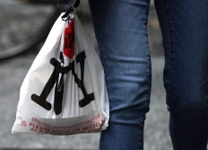A person with their lunch in a plastic bags walks in midtown in New York on February 28, 2020, ahead of the statewide ban on plastic bags that takes effect March 1. 