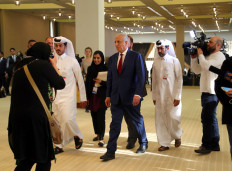 Zalmay Khalilzad, US envoy for peace in Afghanistan, walks ahead of the signing of an agreement between members of Afghanistan's Taliban delegation and the US government in Doha, Qatar on Saturday 