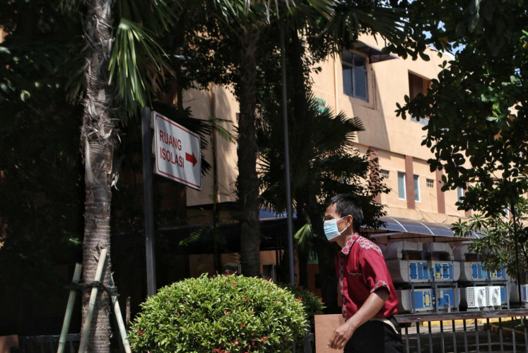 A hospital staffer walks past the isolation building at Sulianti Saroso Infection Hospital on March 2.
