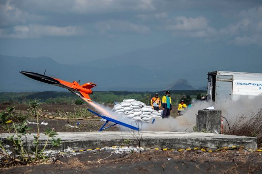 This picture taken on Nov. 19, 2019 shows a miniature test rocket taking off as Indonesia's little-known space agency, the National Institute of Aeronautics and Space (LAPAN), tests equipment on barren scrubland in Lumajang, East Java. It's a long way from a Mission Control in Houston, but the Southeast Asian archipelago's answer to NASA has sky-is-the-limit hopes and is now planning to build its first spaceport on a tropical island off the coast of easternmost Papua. 