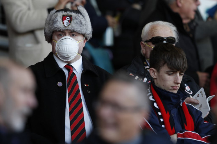 A Bournemouth supporter wears a protective face mask in the stands during the English Premier League football match between Bournemouth and Chelsea at the Vitality Stadium in Bournemouth, southern England on February 29, 2020. 