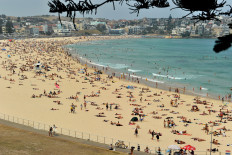 Sunbathers are seen on Bondi Beach as temperatures soar in Sydney on December 21, 2019. 