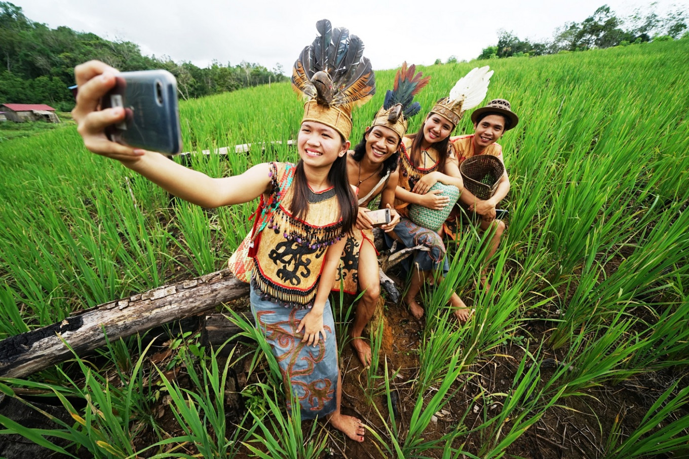 Dayak youths in traditional dress take a selfie in a paddy field in Ansok village, Sintang regency, West Kalimantan, in this file photo from March 2020.