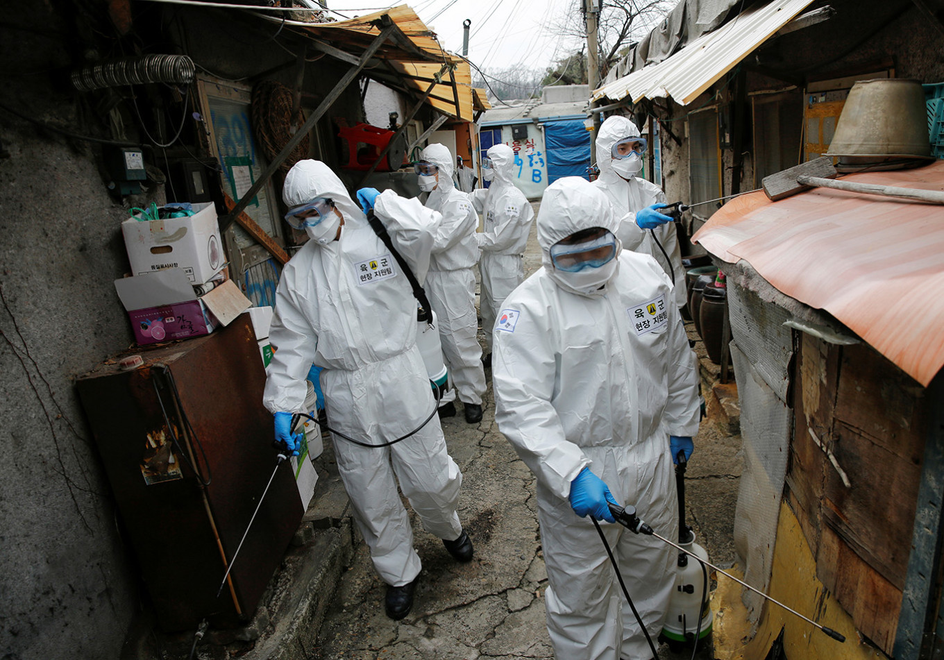 South Korean soldiers in protective gears sanitize shacks at Guryong village in Seoul, South Korea, on Tuesday.