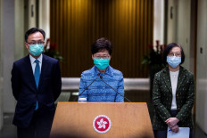 Hong Kong's Chief Executive Carrie Lam (C), Secretary for Constitutional and Mainland Affairs Patrick Nip (L) and Hong Kong's Secretary for Food and Health Sophia Chan (R) take part in a press conference while wearing face masks in Hong Kong on March 3, 2020. 
