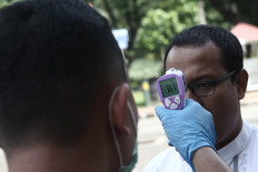 A member of the Presidential Security Detail (Paspampres) checks a visitor's body temperature at the Presidential Palace in Jakarta on Tuesday. Body temperature checks are carried out for all guests, including ministers and heads of state institutions, who enter the palace to prevent the spread of the coronavirus.