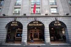 People walk past the Ritz hotel in central London on December 17, 2012. 