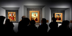 Visitors look at the paintings (left to right) 'Young Man with an Apple', 'Young Woman with Unicorn' and 'Portrait of a Man' by Renaissance master Raffaello Sanzio da Urbino, known as Raphael, on March 4, 2020, displayed at the exhibition 'Raffaello' at the Scuderie del Quirinale in Rome.